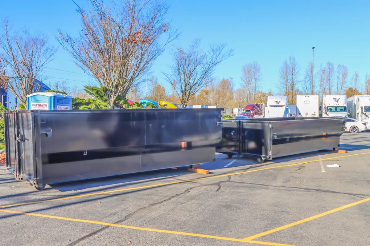 Professional dumpster rental service with roll-off container on residential driveway in Munford